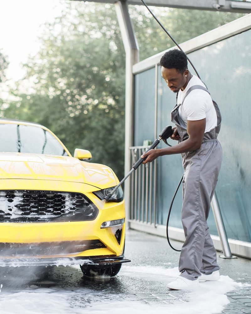 man-washing-his-luxury-yellow-car-under-high-press-TYJVQEK.jpg lavado de coches a domicilio